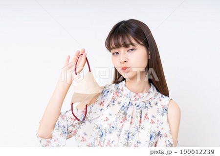 マスクを外す若い女性 100012239