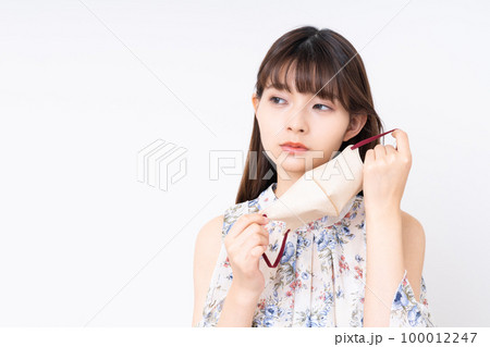 マスクを外す若い女性 100012247