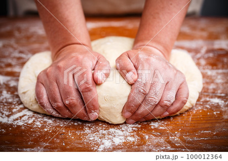 Female hands preparing dough Female hands preparing dough 100012364