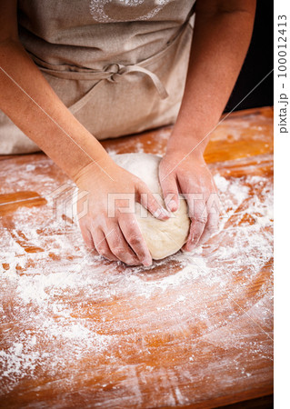 Female hands making bread dough 100012413