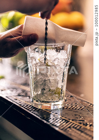 Professional bartender making cocktail 100012985