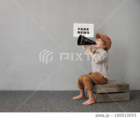 Newsboy shouting against grunge wall background. Boy selling fake news Newsboy shouting against grunge wall background. Boy selling fake news 100013055
