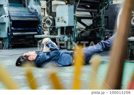 工場で寝転がる労働者 100013206