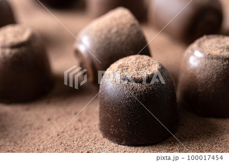 Chocolate bonbons and cocoa powder background 100017454