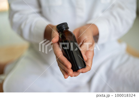 Female scientist in white medical uniform with mock up glass cosmetic jar in hands Female scientist in white medical uniform with mock up glass cosmetic jar in hands 100018324
