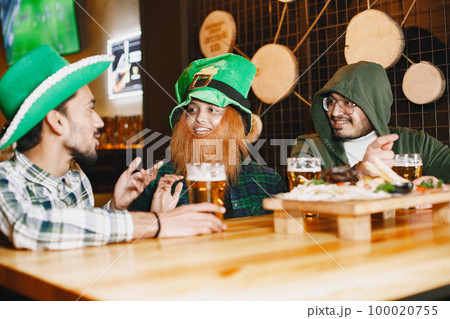 Indian friends celebrate St. Patrick's Day in a pub 100020755