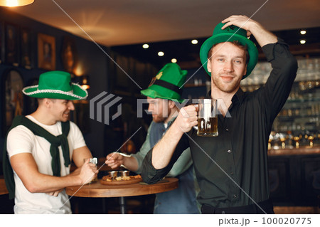 Men celebrate St. Patrick's Day at bar with a mug of beer 100020775
