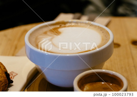 Close-up of a coffee cup with foam on a cafe table 100023793