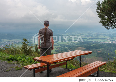Wooden table and benches, hiker with dreadlocks and view from Velky Javornik to Frenstat nad Radhostem, Beskid Mountains Wooden table and benches, hiker with dreadlocks and view from Velky Javornik to Frenstat nad Radhostem, Beskid Mountains 100026753