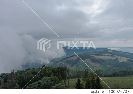View from lookout tower Velky Javornik to Beskid Mountains in summer cloudy evening. The fog rises from the valley to the top 100026783