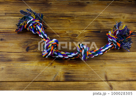 Colorful rope toy for dog on wooden background 100028305