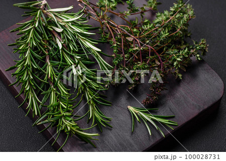 Sprigs of fresh green rosemary on a wooden cutting board 100028731