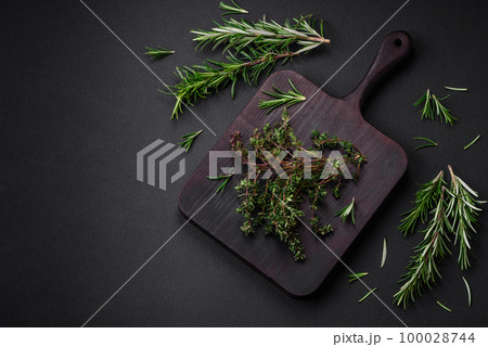 Sprigs of fresh green thyme on a wooden cutting board Sprigs of fresh green thyme on a wooden cutting board 100028744