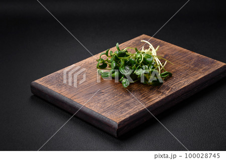 Fresh sprouts or sunflower microgreens on wooden cutting board Fresh sprouts or sunflower microgreens on wooden cutting board 100028745