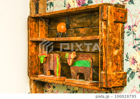 A simple old used wooden box on the wall of the room as a shelf in a vintage style interior A simple old used wooden box on the wall of the room as a shelf in a vintage style interior 100028795