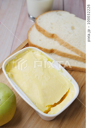 fresh butter in a container with bread on white background  100032226