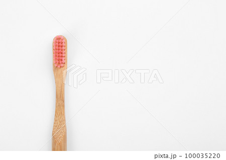 Bamboo toothbrush with pink bristle isolated on white, top view Bamboo toothbrush with pink bristle isolated on white, top view 100035220