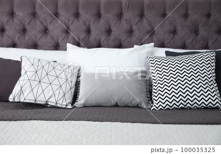 Soft pillows on modern bed in room 100035325
