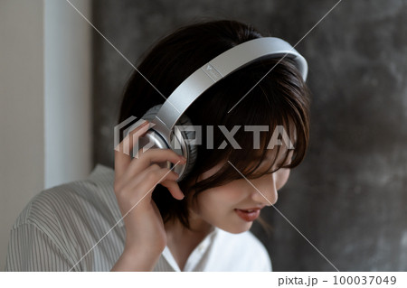 ヘッドフォンで音楽を聴くZ世代の女性 ヘッドフォンで音楽を聴くZ世代の女性 100037049