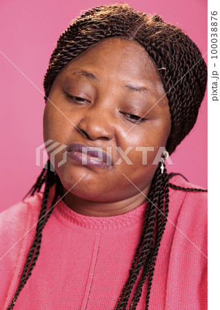 Portrait of unpleasant african american young adult with disgusted expression repulsing something in sudio standing over pink background. Displeased woman being annoying by bad smell Portrait of unpleasant african american young adult with disgusted expression repulsing something in sudio standing over pink background. Displeased woman being annoying by bad smell 100038876