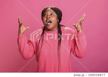 Portrait of frustrated model feeling angry and mad while doing exasperated hand gesture in studio. Furious stressed woman having a breakdown posing aggresive, showing unhappy reaction. 100038877