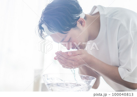 ヘアバンドをして洗顔をする若い男性 ヘアバンドをして洗顔をする若い男性 100040813