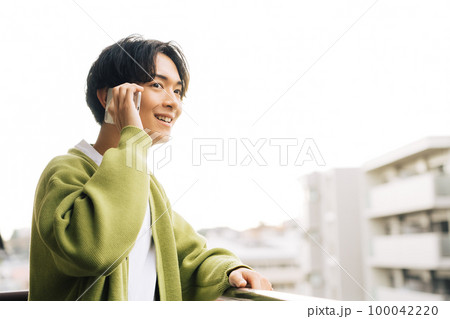 ベランダで電話をする男性 ベランダで電話をする男性 100042220