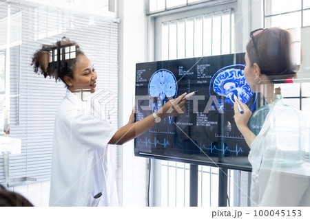 View through glass, Team doctor presentation of brain x-ray results through screen to present. 100045153