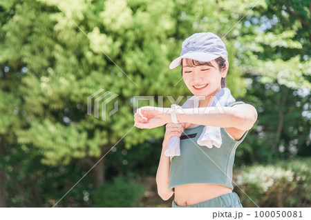 公園で腕時計を見ながら運動・トレーニング・ウォーキングする女性(時間・タイム・ヘルスケア) 公園で腕時計を見ながら運動・トレーニング・ウォーキングする女性(時間・タイム・ヘルスケア) 100050081