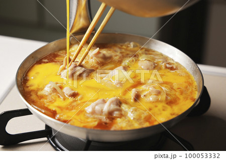 溶き卵を入れた親子丼の調理シーン 100053332