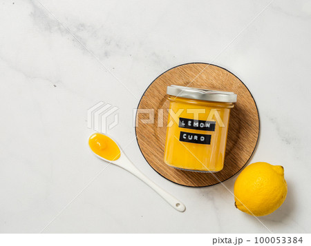 Homemade lemon curd in jar, top view, vertical 100053384