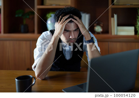 Portrait of an Asian man to be bored from working on a computer. 100054120