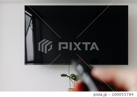 Hand holding remote point at tv. Concept of watching tv. 100055784