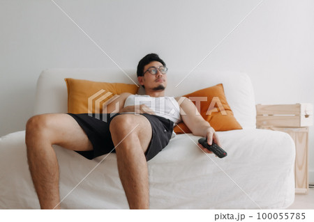Boring life and lonely man watching tv in his living room. 100055785