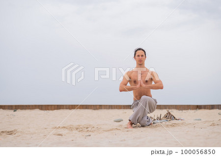 Caucasian man practices martial arts outdoors. balance and meditation. 100056850