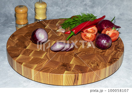 Wooden board for cutting handmade products with chopped vegetables. On a light background. 100058107
