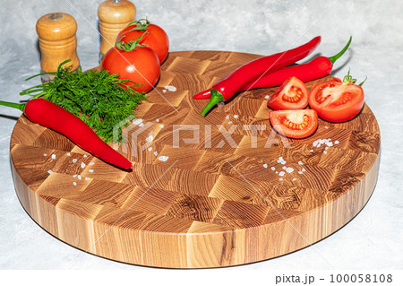 Wooden board for cutting handmade products with chopped vegetables. On a light background. 100058108