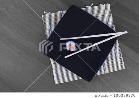 close-up of sushi and chopsticks on a wooden table 100059570