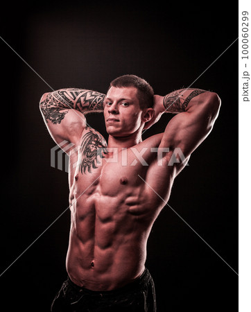 athletic male bodybuilder holding hands behind head 100060299