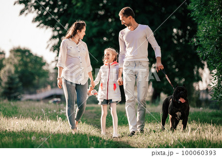 happy family with their pet for a walk in the Park. 100060393