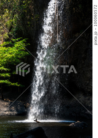 Splashing waterfall drop on pond with dark background of cave. Splashing waterfall drop on pond with dark background of cave. 100060572