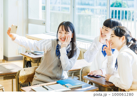 教室でスマホを使って自撮りをする女子高生 教室でスマホを使って自撮りをする女子高生 100061280