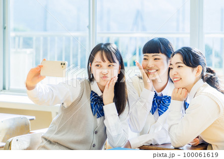 教室でスマホを使って自撮りをする女子高生 教室でスマホを使って自撮りをする女子高生 100061619