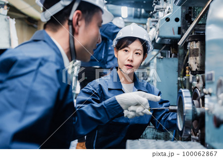 工場で作業を教えてもらう外国人労働者 100062867