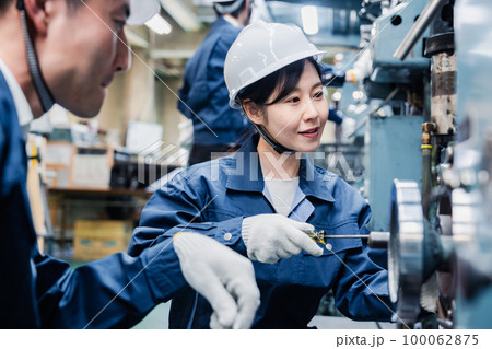 工場で作業を教えてもらう外国人労働者 100062875