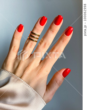 Beautiful nails manicure photo. Red color top nail polish. Female hand, rings, closeup photo, aesthetics. Manicure design, square nail shape. Luxury style, Creative beauty photo, Woman hand. High Beautiful nails manicure photo. Red color top nail polish. Female hand, rings, closeup photo, aesthetics. Manicure design, square nail shape. Luxury style, Creative beauty photo, Woman hand. High 100062998