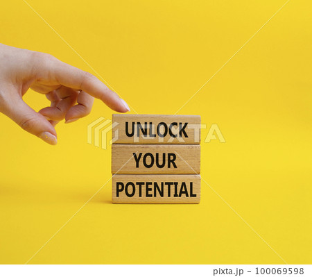 Unlock your Potential symbol. Wooden blocks with words Unlock your Potential. Beautiful yellow background. Businessman hand. Business and Unlock your Potential concept. Copy space. 100069598