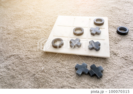 Marble Tic Tac Toe or OX board game on soft carpet with copy space. concept of strategy, risk, competition in business. 100070315