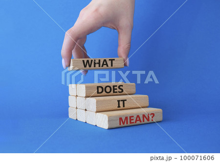What does it mean symbol. Wooden blocks with words What does it mean. Businessman hand. Beautiful blue background. Business and What does it mean concept. Copy space. 100071606