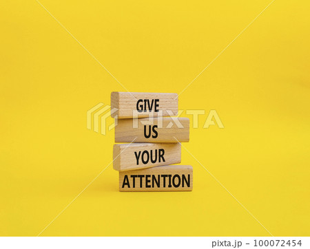 Attention symbol. Concept word Give us your attention on wooden blocks. Beautiful yellow background. Business and Give us your attention concept. Copy space 100072454